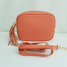 Lataa kuva Galleria-katseluun, Oranssi ANGIE olkalaukku on aitoa nahkaa. Laukussa on kaksi säädettävää olkahihnaa ja vetoketjukiinnitys. Tupsukoriste toimii vetimenä. Suosittu crossbody malli.