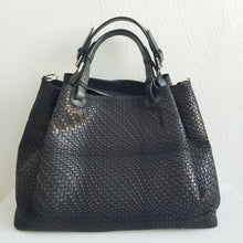 Lataa kuva Galleria-katseluun, Upea CHIARA laukku on tunnetun Bottega Veneta brändin inspiroima malli. Tyylikäs ja tilava laukku on valmistettu aidosta intrecciato punotusta nahasta. Sisällä on vetoketjullinen tilanjakaja sekä vetoketjullinen sivutasku ja avotasku. Väri: musta Kantokahvat ja olkahihna voi säätää. Koko: korkeus 32 cm, leveys 50 cm, syvyys 19 cm Olkahihnan koko: leveys 2 cm, max pituus 125 cm Valmistettu Italiassa.
