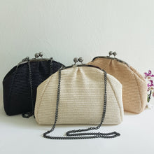 Lataa kuva Galleria-katseluun, LUISA on näyttävä ja kevyt clutch-mallinen laukku, jossa yhdistyvät luonnollinen raffiapinta ja tummanhopean sävyinen metalliketju. Punottu rakenne tuo laukkuun kesäistä tekstuuria, kun taas metallinen kehys ja klipsilukko antavat sille elegantin, juhlaan sopivan ilmeen.
Irrotettavan metallihihnan ansiosta laukkua voi kantaa olalla tai kädessä clutch-tyyliin. Sisällä on vetoketjullinen sivutasku pikkutavaroille.