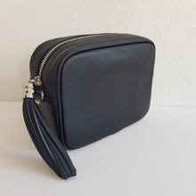 Lataa kuva Galleria-katseluun, ANGIE laukussa on kaksi säädettävää olkahihnaa ja vetoketjukiinnitys. Tupsukoriste toimii vetimenä. Erittäin suosittu crossbody malli.  Laukussa yksi tasku ja pieni avotasku ja tekstiilivuorikangas.  Väri: musta  Materiaali nahka
