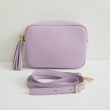 Lataa kuva Galleria-katseluun, ANGIE olkalaukku on aitoa nahkaa. Laukussa on kaksi säädettävää olkahihnaa ja vetoketjukiinnitys. Tupsukoriste toimii vetimenä. Erittäin suosittu cross body malli.  Väri: lila
