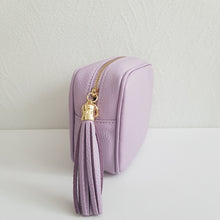 Lataa kuva Galleria-katseluun, ANGIE olkalaukku on aitoa nahkaa. Laukussa on kaksi säädettävää olkahihnaa ja vetoketjukiinnitys. Tupsukoriste toimii vetimenä. Erittäin suosittu cross body malli.  Väri: lila
