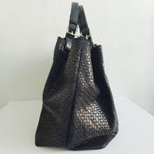 Lataa kuva Galleria-katseluun, Upea CHIARA laukku on tunnetun Bottega Veneta brändin inspiroima malli. Tyylikäs ja tilava laukku on valmistettu aidosta intrecciato punotusta nahasta. Sisällä on vetoketjullinen tilanjakaja sekä vetoketjullinen sivutasku ja avotasku.  Väri: musta  Kantokahvat ja olkahihna voi säätää.  Koko: korkeus 32 cm, leveys 50 cm, syvyys 19 cm  Olkahihnan koko: leveys 2 cm, max pituus 125 cm  Valmistettu Italiassa.
