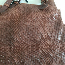 Lataa kuva Galleria-katseluun, Upea CHIARA laukku on tunnetun Bottega Veneta brändin inspiroima malli. Tyylikäs ja tilava laukku on valmistettu aidosta intrecciato punotusta nahasta. Sisällä on vetoketjullinen tilanjakaja sekä vetoketjullinen sivutasku sekä avotasku   Väri: ruskea  Kantokahvat ja olkahihna on säädettävät.  Koko: korkeus 32 cm, leveys 50 cm, syvyys  19  cm  Olkahihnan koko: leveys  2 cm, max pituus 125   cm  Valmistettu Italiassa.
