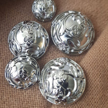 Lataa kuva Galleria-katseluun, Kaunis metallinen kukkanappi kannalla. Napin pinnassa on kukkaköynnöksen kohokuvio. Väri on kirkas hopea, koot 15 mm, 18 mm, 23 mm, 25 mm, 28 mm.
