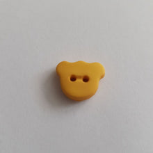 Lataa kuva Galleria-katseluun, Matta pintainen nalle-nappi, 15 mm leveys, läpiommeltava, 2 reikää. Hauska ja värikäs nappi sopii lasten paitoihin, neuleisiin, mekkoihin ja käy koristenapiksi.  Kymmenen eri väriä: valkoinen, beige, vaaleanpunainen, keltainen, punainen, oranssi, lila, sinappi, turkoosi, tummansininen, tummanruskea, musta.
