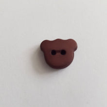 Lataa kuva Galleria-katseluun, Matta pintainen nalle-nappi, 15 mm leveys, läpiommeltava, 2 reikää. Hauska ja värikäs nappi sopii lasten paitoihin, neuleisiin, mekkoihin ja käy koristenapiksi.  Kymmenen eri väriä: valkoinen, beige, vaaleanpunainen, keltainen, punainen, oranssi, lila, sinappi, turkoosi, tummansininen, tummanruskea, musta.
