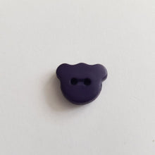 Lataa kuva Galleria-katseluun, Matta pintainen nalle-nappi, 15 mm leveys, läpiommeltava, 2 reikää. Hauska ja värikäs nappi sopii lasten paitoihin, neuleisiin, mekkoihin ja käy koristenapiksi.  Kymmenen eri väriä: valkoinen, beige, vaaleanpunainen, keltainen, punainen, oranssi, lila, sinappi, turkoosi, tummansininen, tummanruskea, musta.

